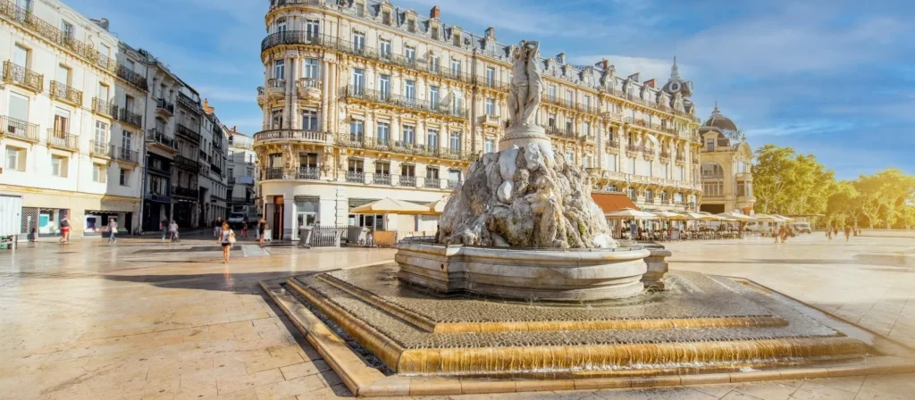 Au premier plan, une fontaine célèbre de la ville de Montpellier avec en fond la ville.