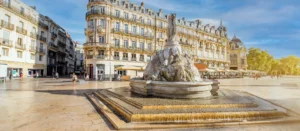 Au premier plan, une fontaine célèbre de la ville de Montpellier avec en fond la ville.