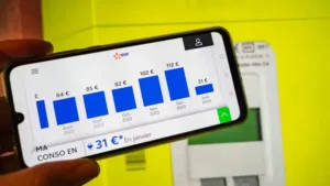 Un téléphone portable en premier plan met en avant les économies réalisees grace à un compte Linky