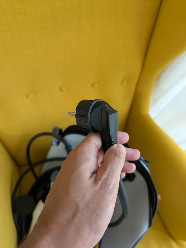 Prise Schuko du chargeur Rheidon PC200-3K6 tenue en main, avec son câble
