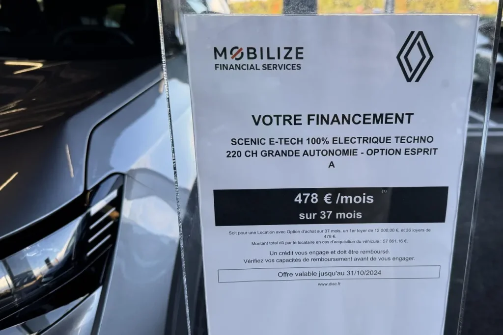 Au premier plan, la fiche de vente d'une voiture vendue en LOA. Le véhicule en question est au second plan